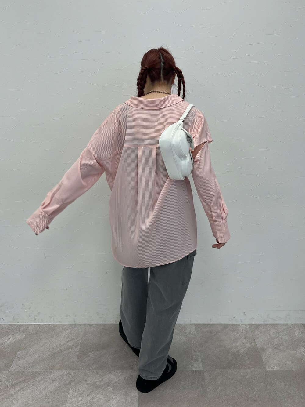 ブラック系のデニムパンツ、ブラック系のサンダル、ピンク系のシャツ/ブラウスを着用したレディースの春コーディネートの2枚目の写真