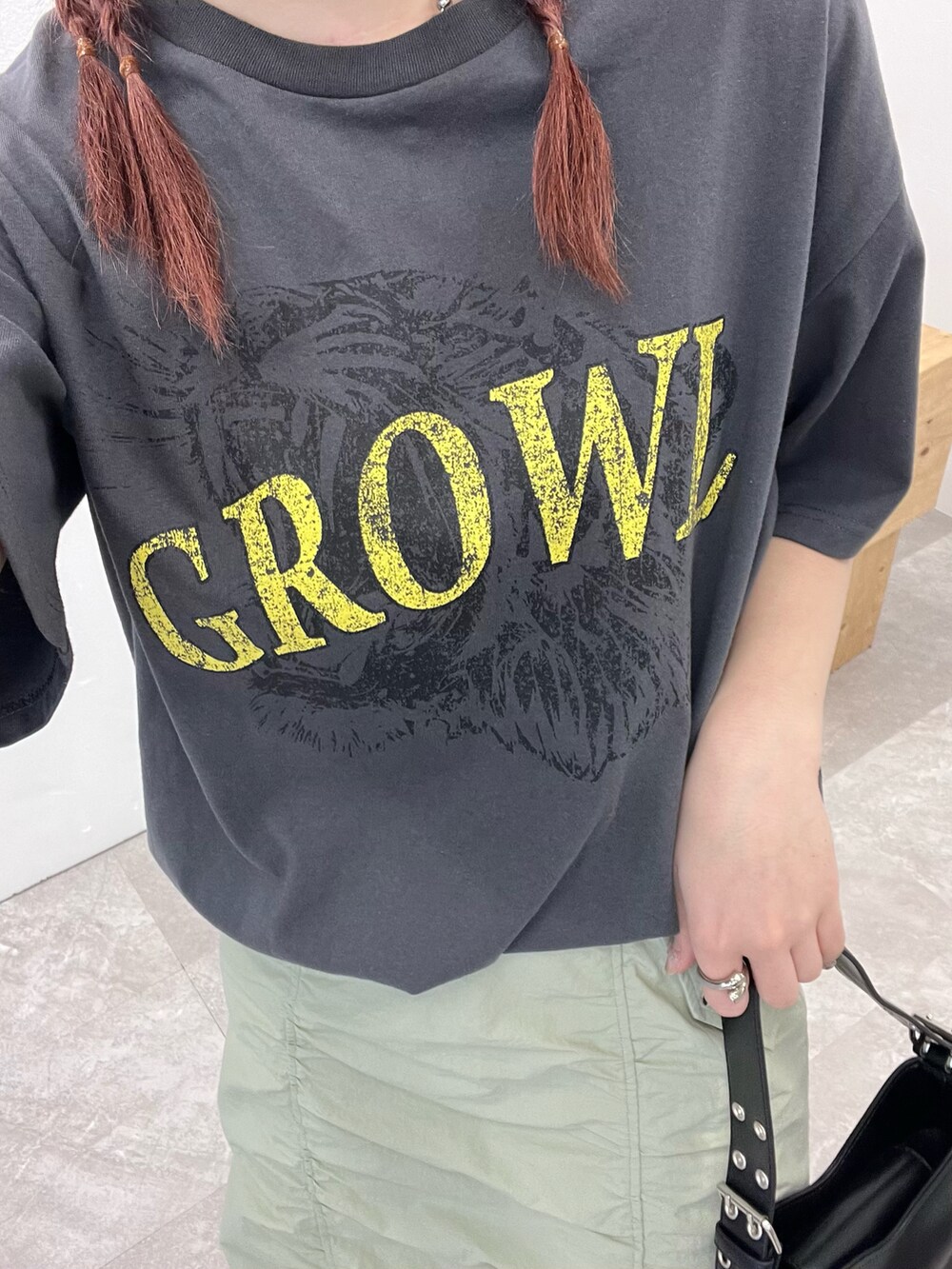 グレー系のTシャツ/カットソー、グリーン系のスカート、ブラック系のサンダルを着用したレディースの春コーディネートの5枚目の写真