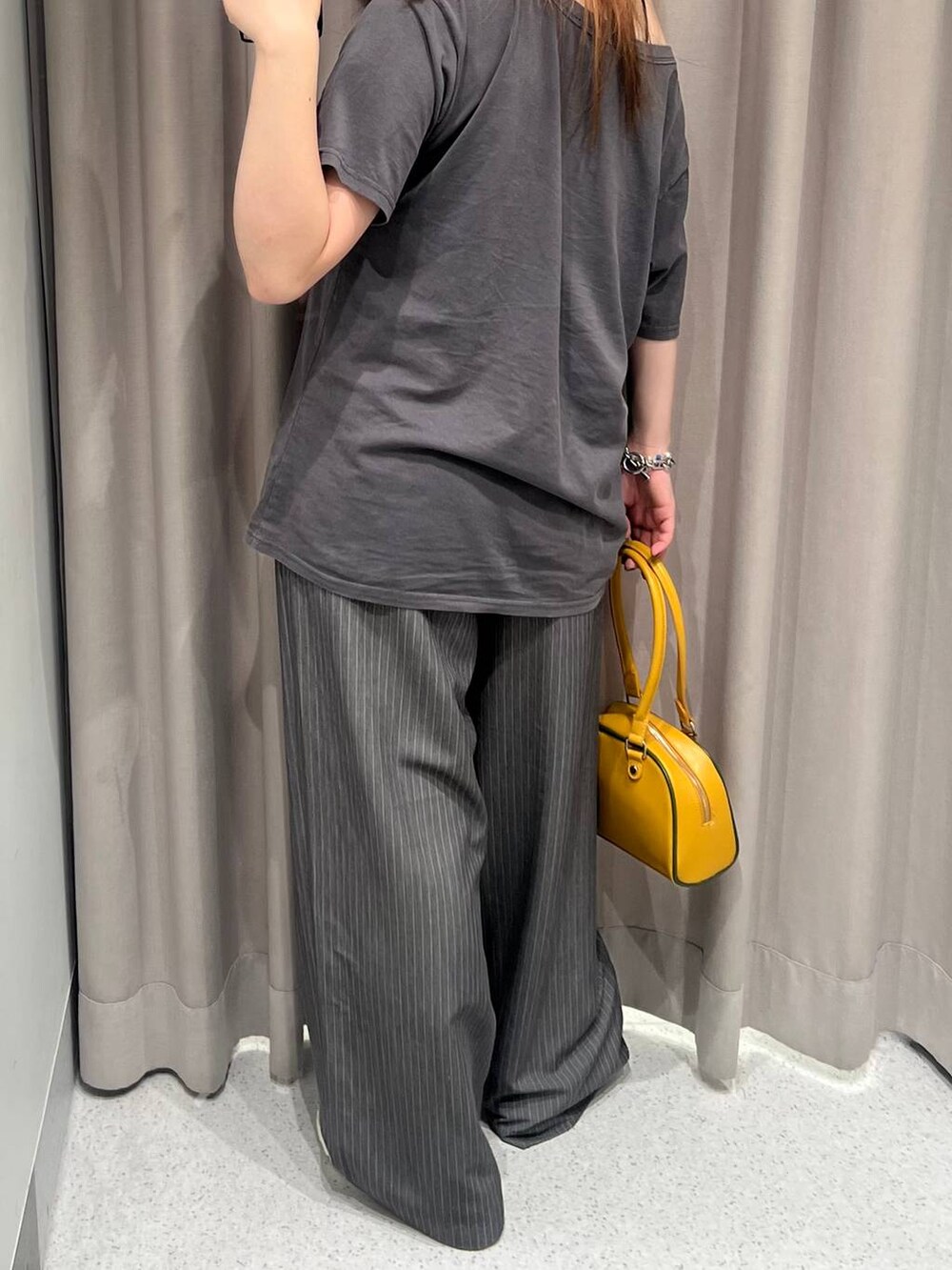 ブラック系のキャミソール、イエロー系のボストンバッグ、グレー系のTシャツ/カットソーを着用したレディースの夏コーディネートの4枚目の写真