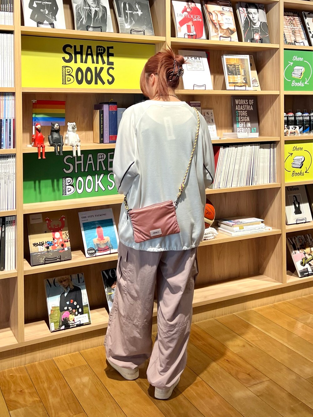 ピンク系のカーゴパンツ、ピンク系のショルダーバッグ、ホワイト系のスウェットを着用したレディースの春コーディネートの5枚目の写真