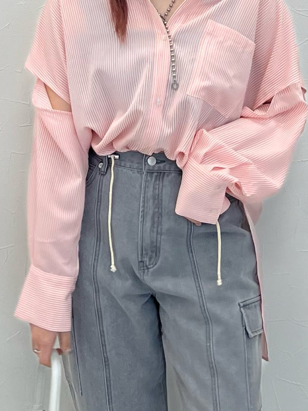 ブラック系のデニムパンツ、ブラック系のサンダル、ピンク系のシャツ/ブラウスを着用したレディースの春コーディネートの3枚目の写真