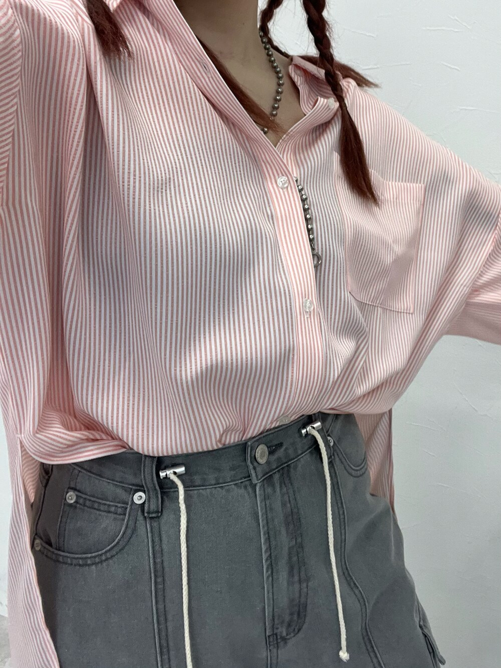 ブラック系のデニムパンツ、ブラック系のサンダル、ピンク系のシャツ/ブラウスを着用したレディースの春コーディネートの5枚目の写真