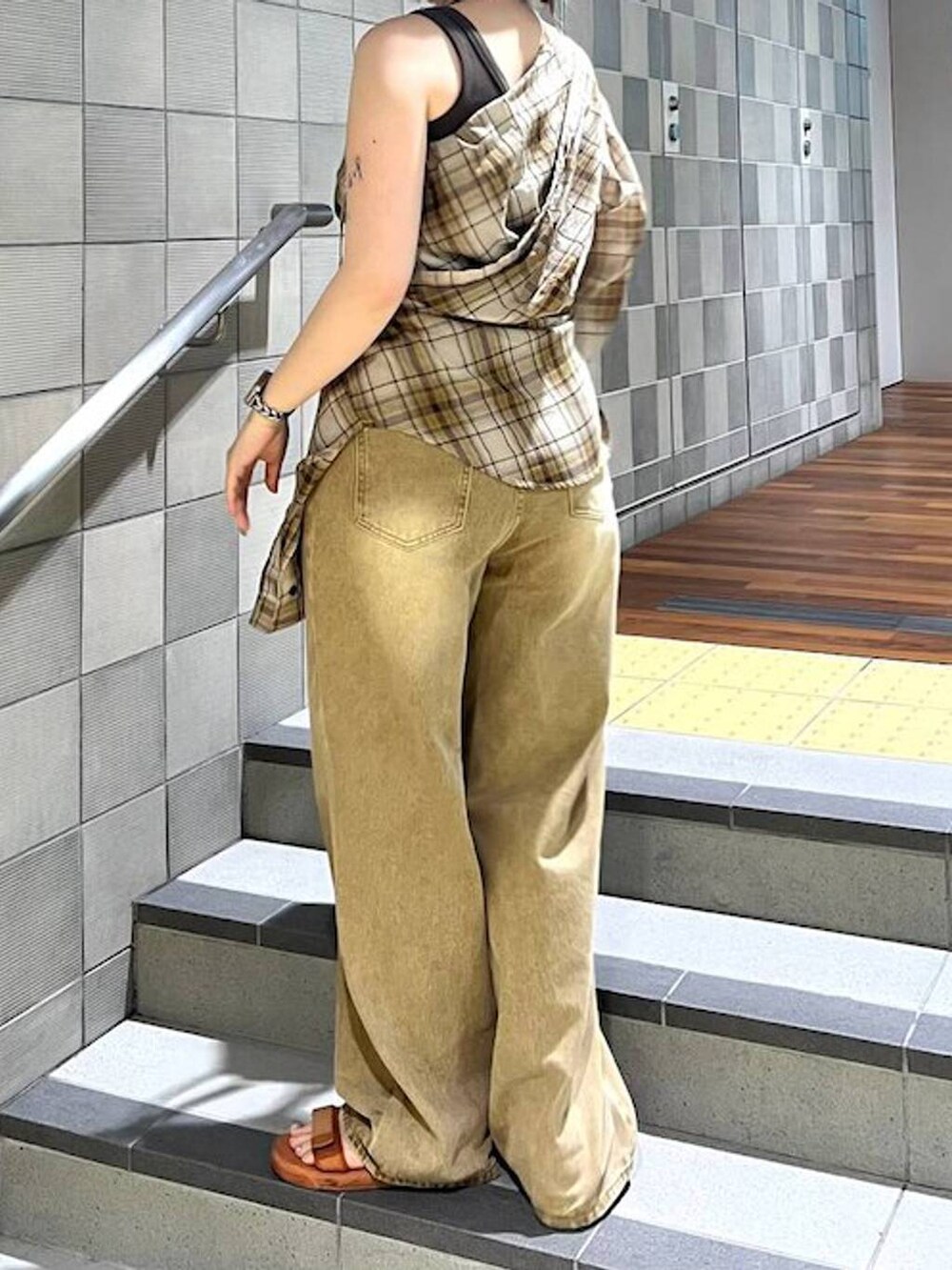 レッド系のボストンバッグ、イエロー系のシャツ/ブラウス、ブラウン系のデニムパンツを着用したレディースの夏コーディネートの2枚目の写真