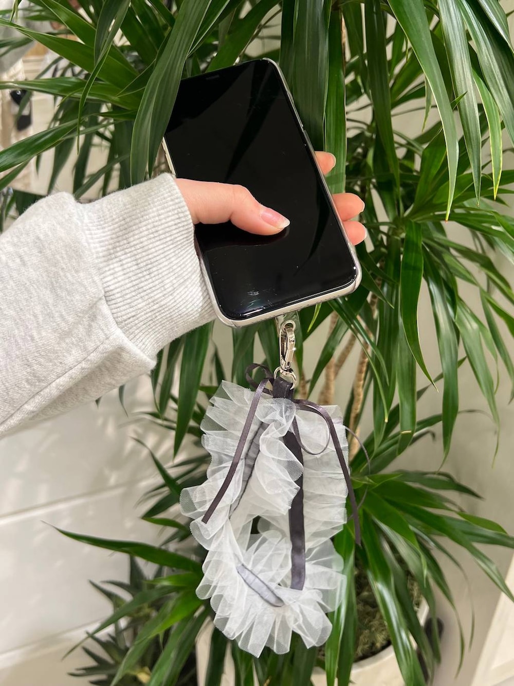 グレー系のスマホグッズを着用したレディースの秋コーディネートの2枚目の写真