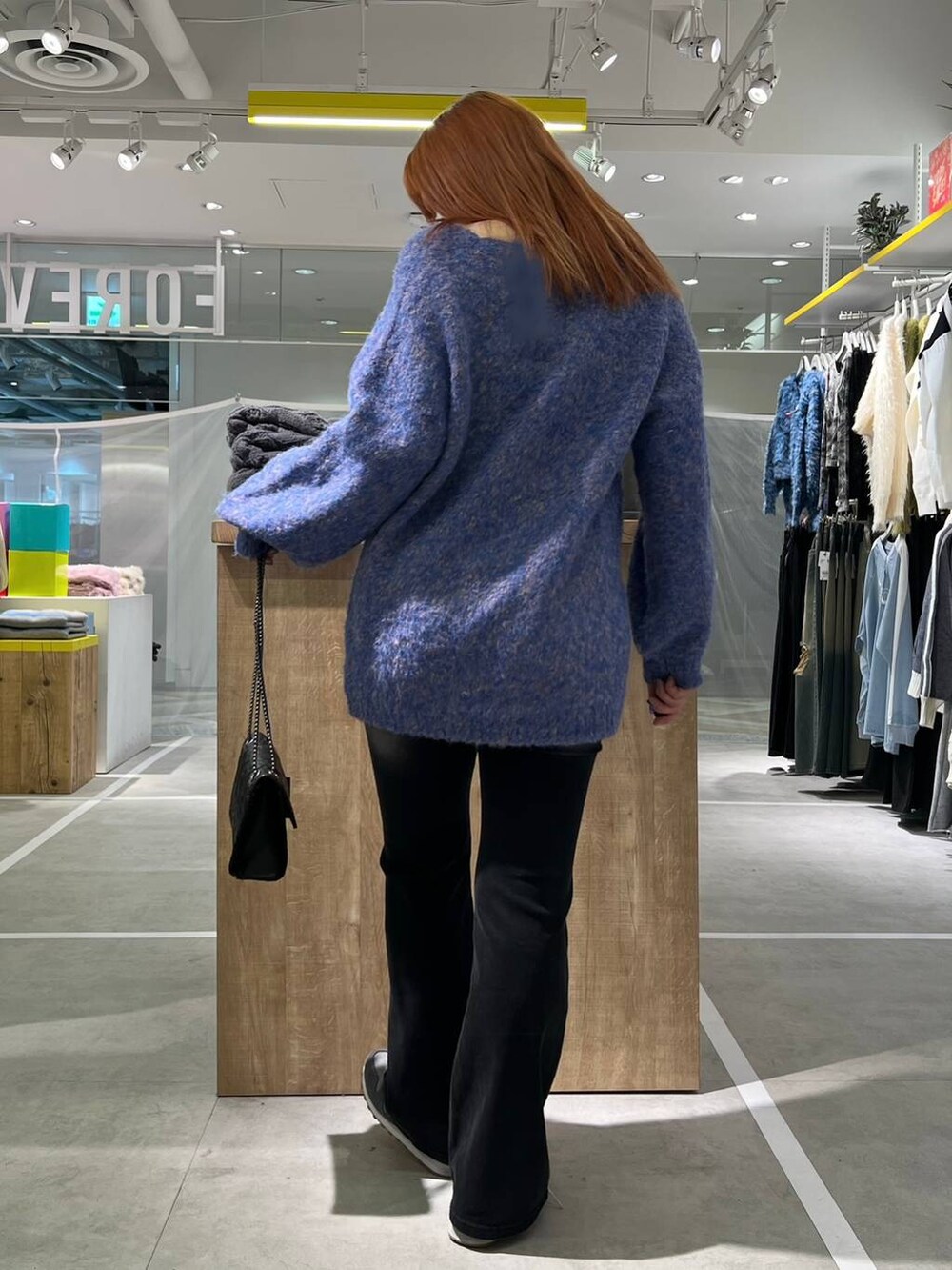 ブルー系のカーディガン/ボレロ、ブラック系のデニムパンツを着用したレディースの冬コーディネートの3枚目の写真