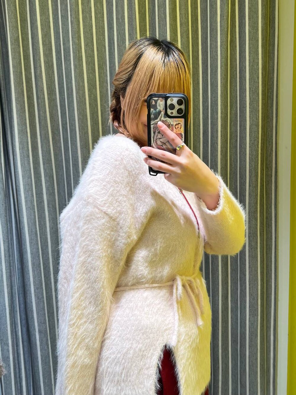 ピンク系のチュニック、レッド系のネックレスを着用したレディースの冬コーディネートの3枚目の写真