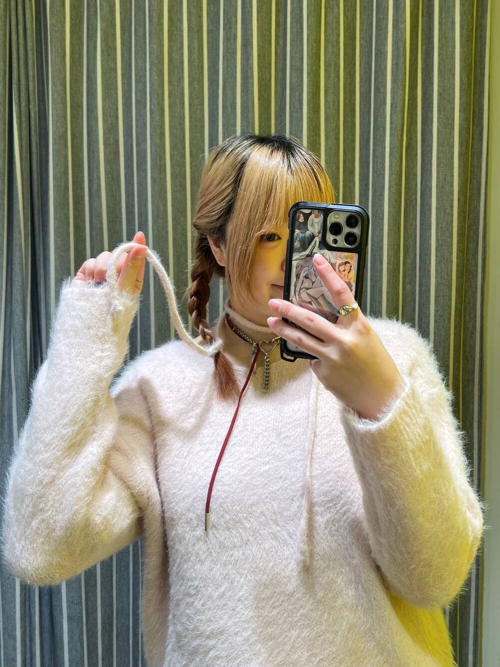 ピンク系のチュニック、レッド系のネックレスを着用したレディースの冬コーディネートの2枚目の写真