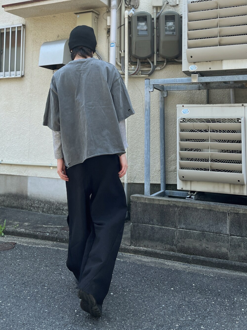 ブラック系のスラックス、グレー系のスニーカー、グリーン系のニットキャップ/ビーニーを着用したメンズの春コーディネートの2枚目の写真