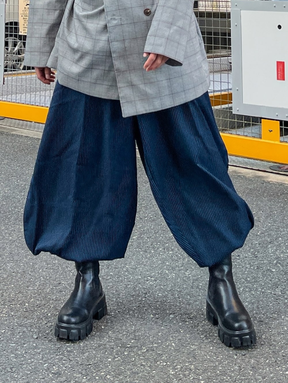 グレー系のテーラードジャケット、ブルー系のパンツ、ブラック系のブーツを着用したメンズの春コーディネートの3枚目の写真