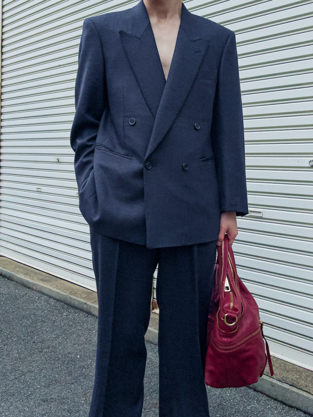 ブルー系のスラックス、ブルー系のテーラードジャケット、ブラック系のブーツを着用したメンズの春コーディネートの2枚目の写真