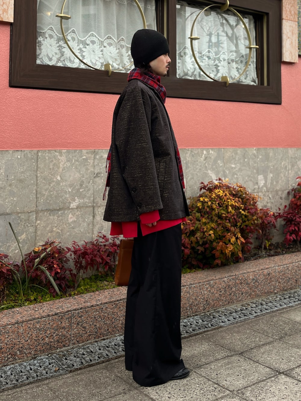 ブラウン系のジャケット/アウター、ブラック系のスラックス、グリーン系のニットキャップ/ビーニーを着用したメンズの冬コーディネートの2枚目の写真