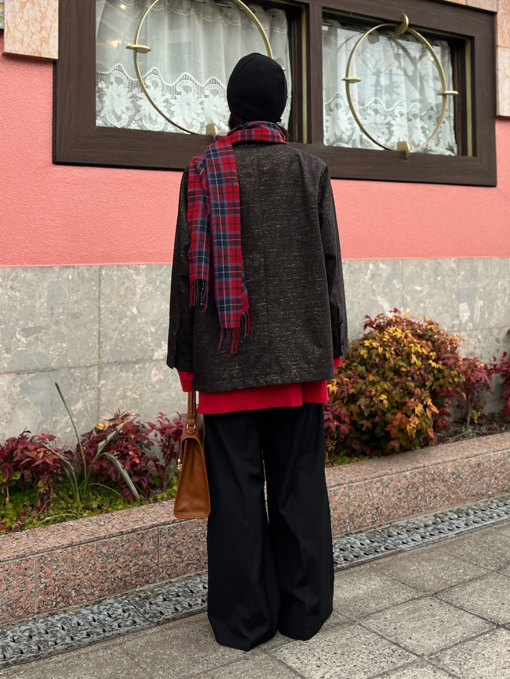 ブラウン系のジャケット/アウター、ブラック系のスラックス、グリーン系のニットキャップ/ビーニーを着用したメンズの冬コーディネートの3枚目の写真