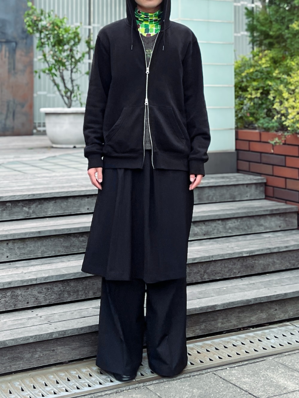 ブラック系のパーカー、ブラック系のスカート、ブラック系のスラックスを着用したメンズの夏コーディネートの2枚目の写真