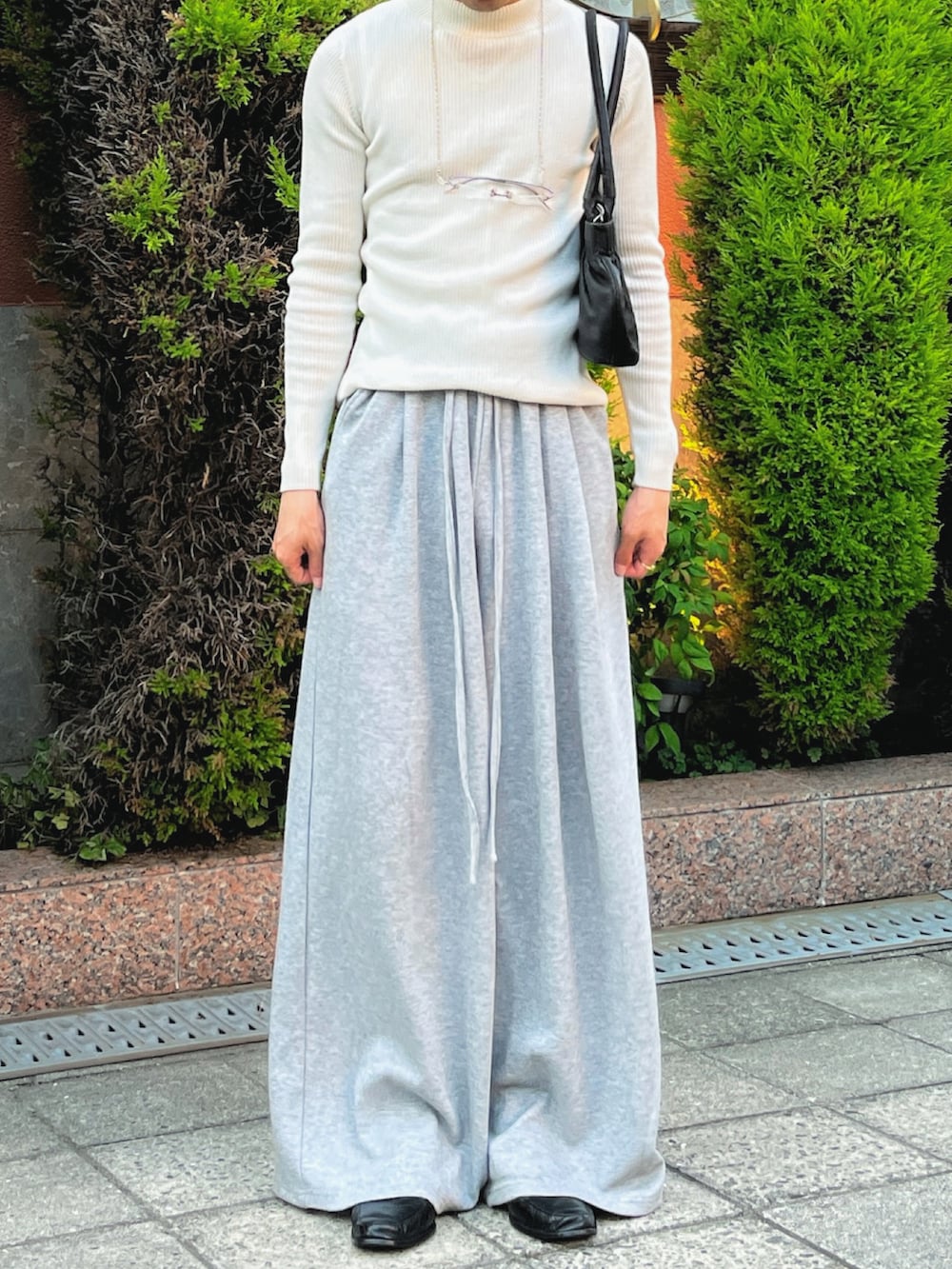 ブラック系のハンドバッグ、グレー系のスウェットパンツ、ブラック系のローファーを着用したメンズの夏コーディネートの2枚目の写真