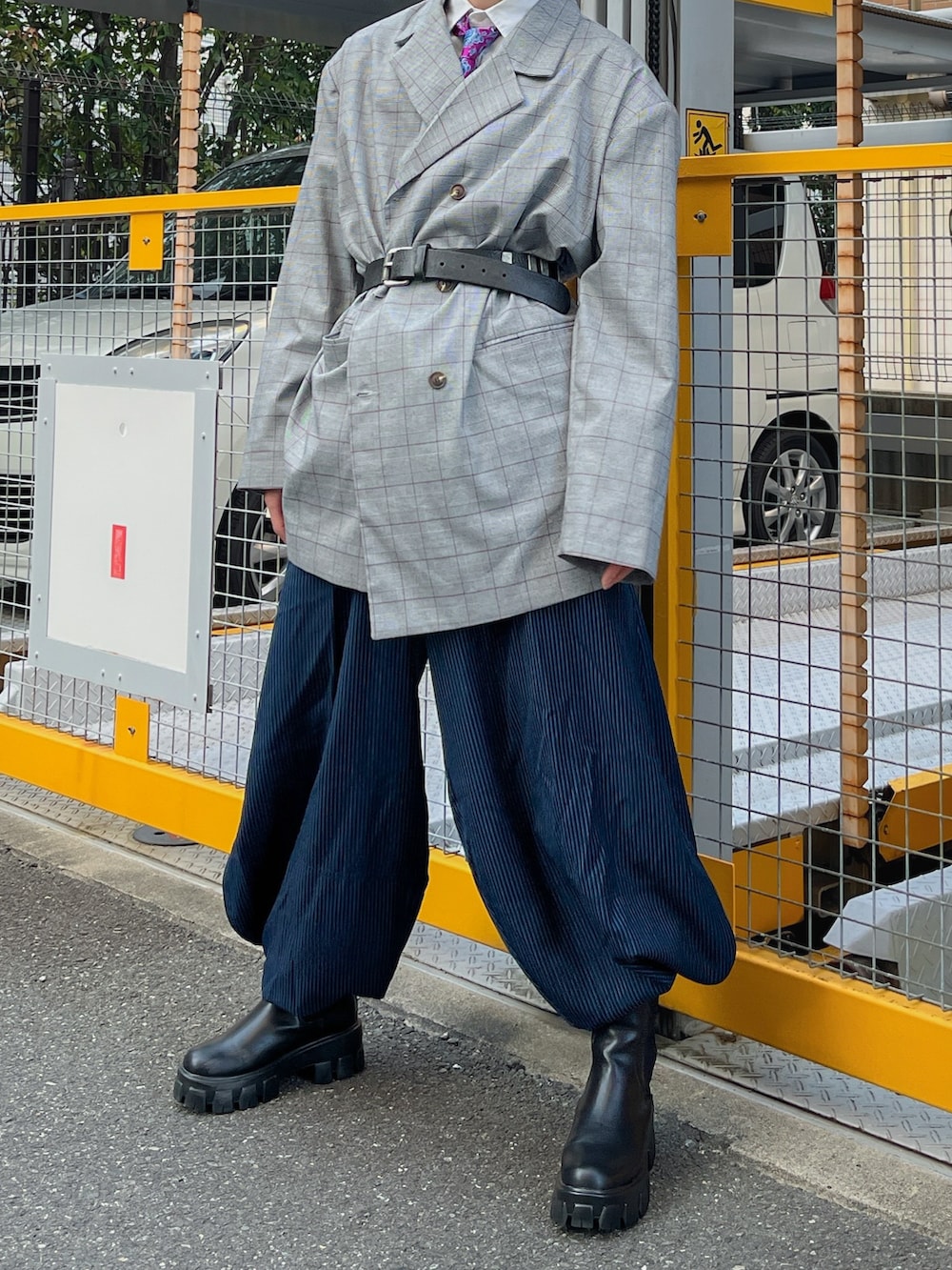 グレー系のテーラードジャケット、ブルー系のパンツ、ブラック系のブーツを着用したメンズの春コーディネートの2枚目の写真