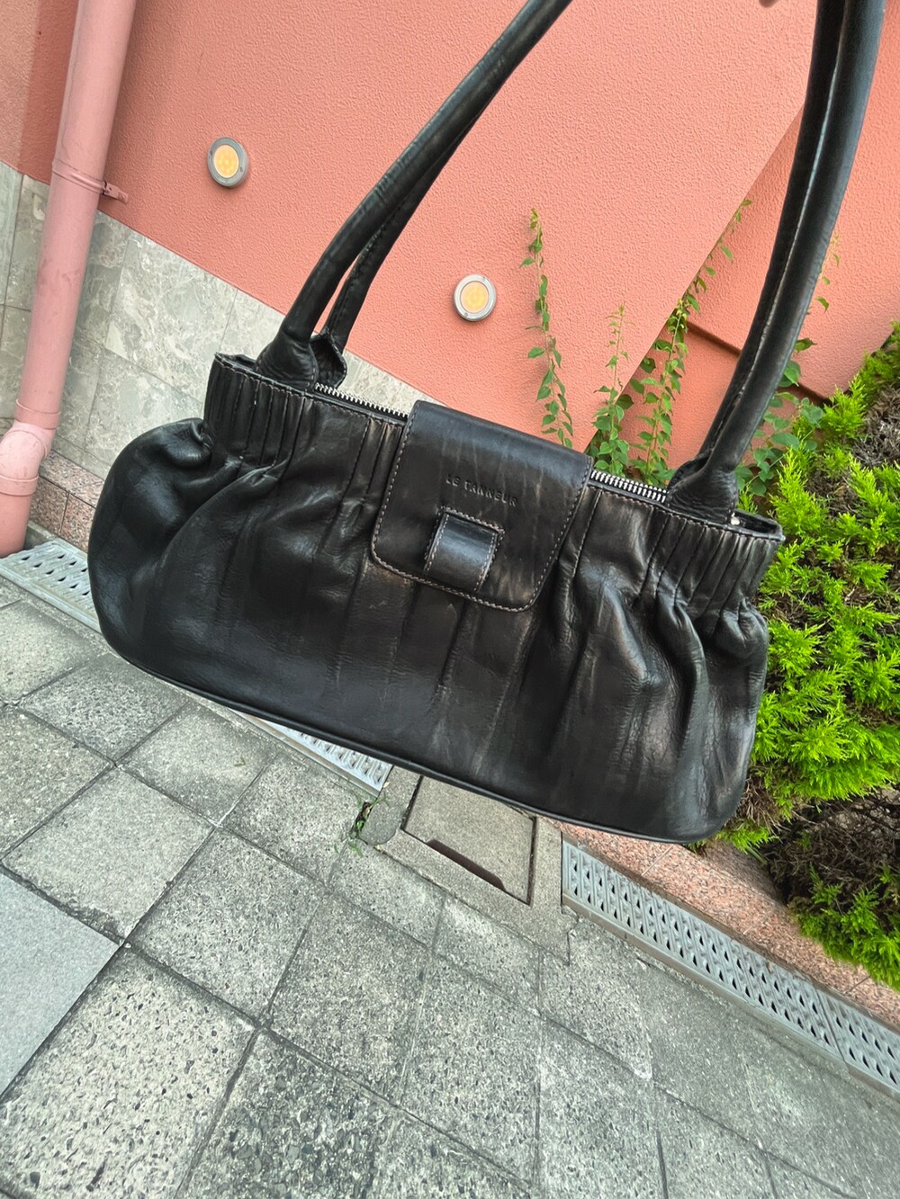 ブラック系のハンドバッグ、グレー系のスウェットパンツ、ブラック系のローファーを着用したメンズの夏コーディネートの3枚目の写真