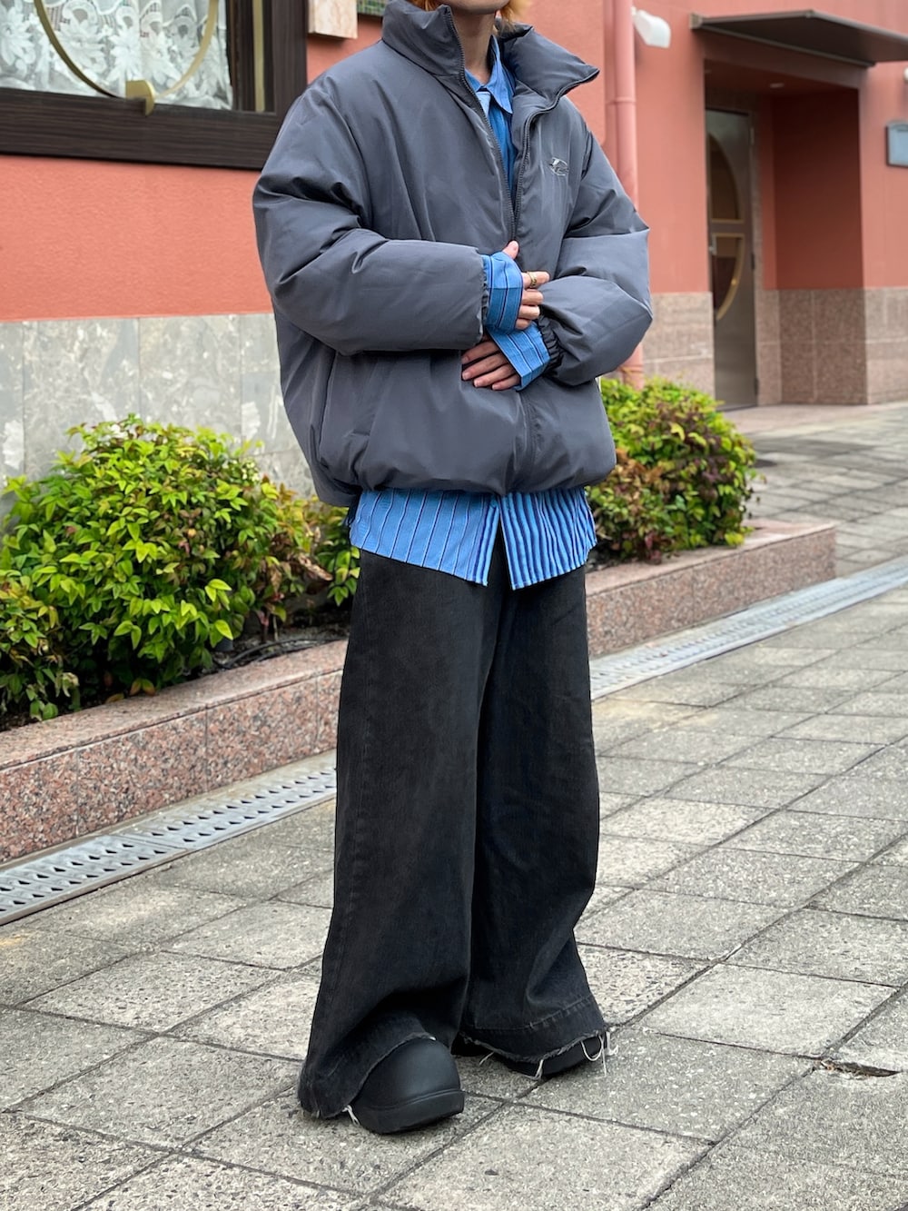 グレー系のダウンジャケット/コート、ブラック系のデニムパンツ、ブルー系のシャツ/ブラウスを着用したメンズの秋コーディネートの3枚目の写真