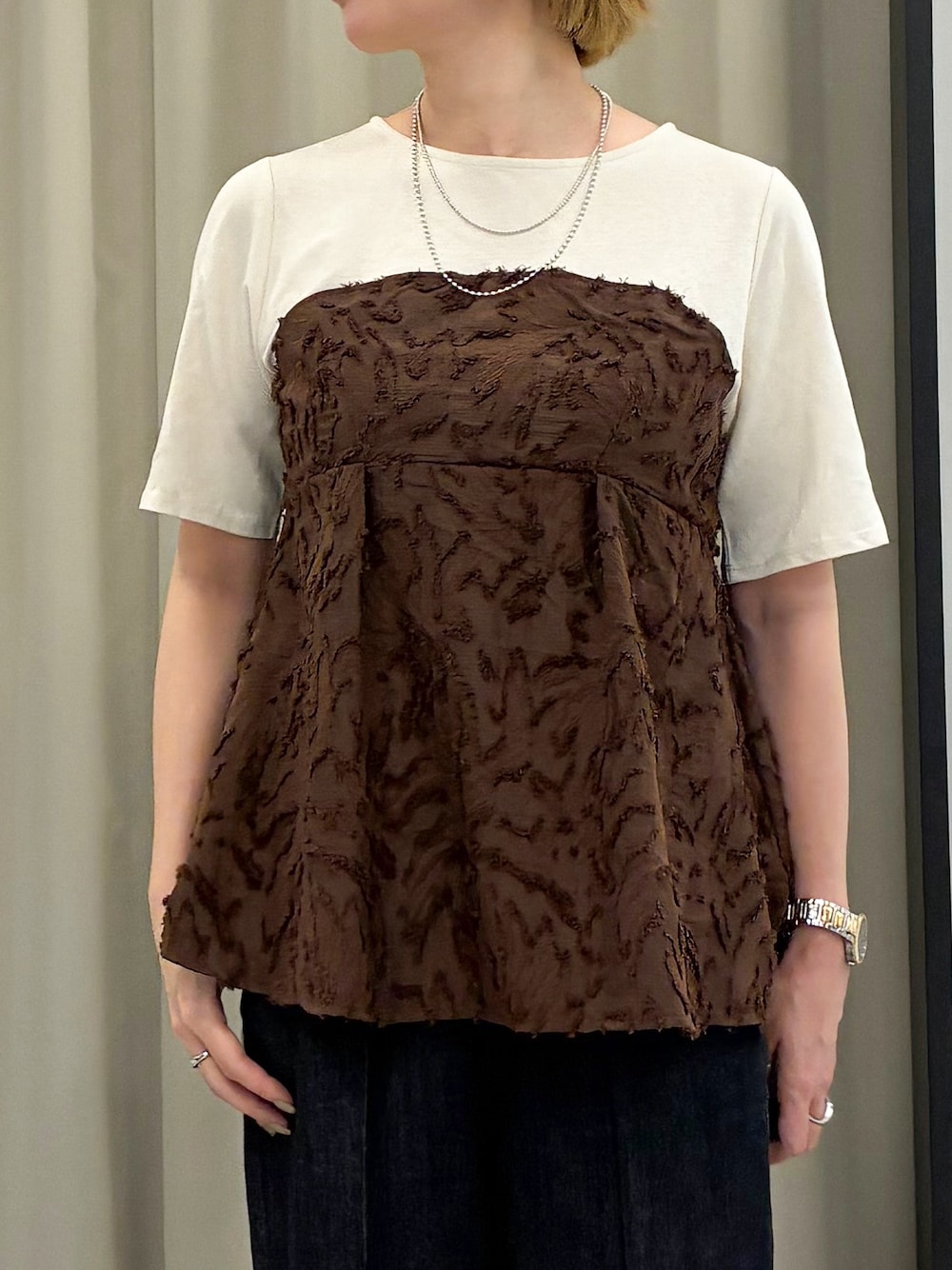 ブラウン系のTシャツ/カットソー、ブラック系のデニムパンツ、ブラック系のショルダーバッグを着用したレディースの秋コーディネートの4枚目の写真