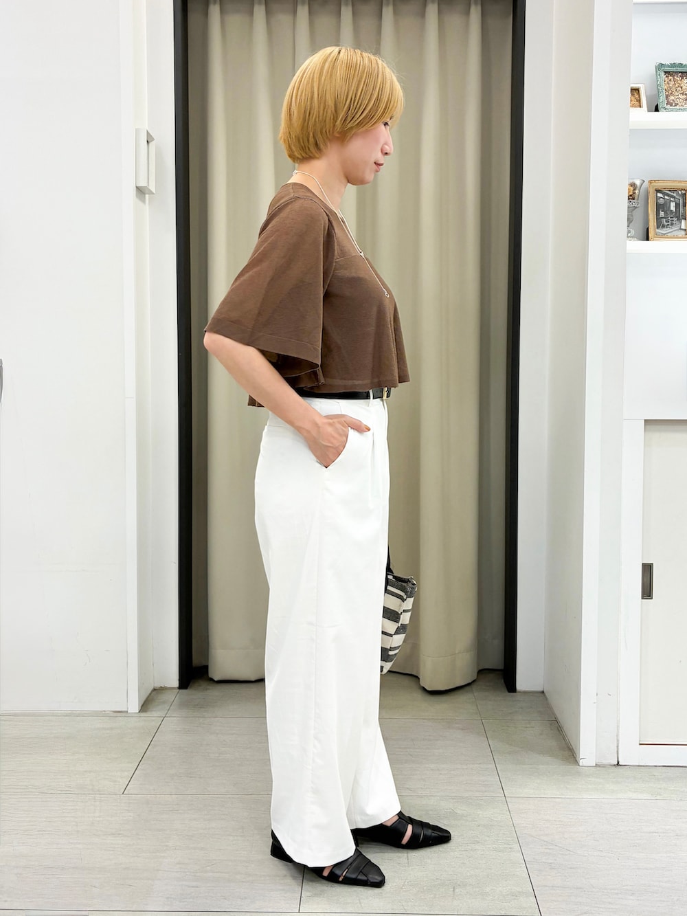 ブラウン系のニット/セーター、ホワイト系のその他パンツ、ベージュ系のトートバッグを着用したレディースの夏コーディネートの2枚目の写真