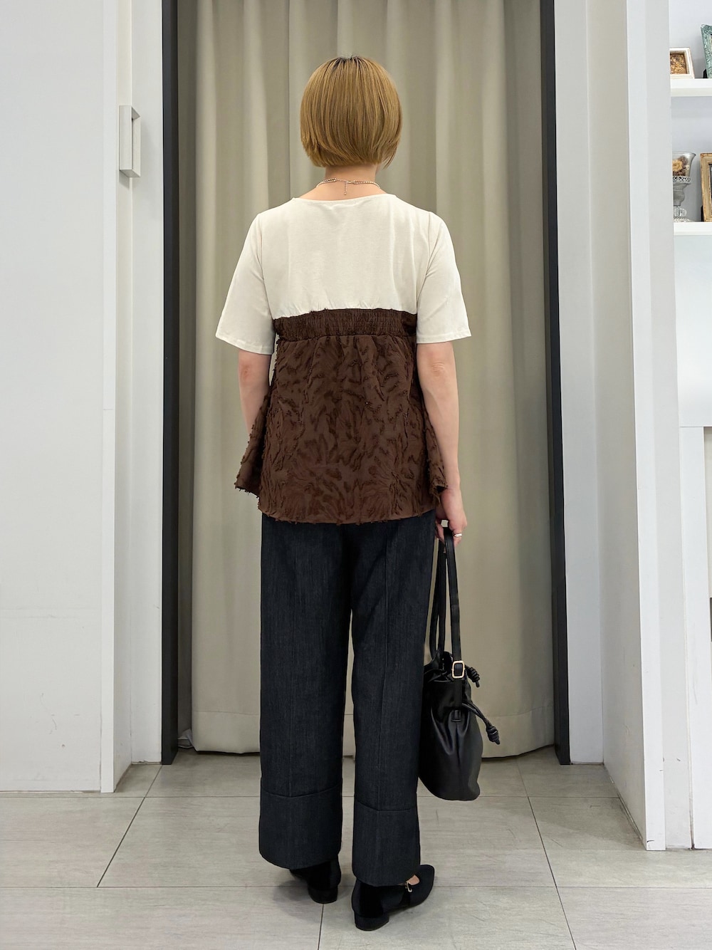 ブラウン系のTシャツ/カットソー、ブラック系のデニムパンツ、ブラック系のショルダーバッグを着用したレディースの秋コーディネートの3枚目の写真