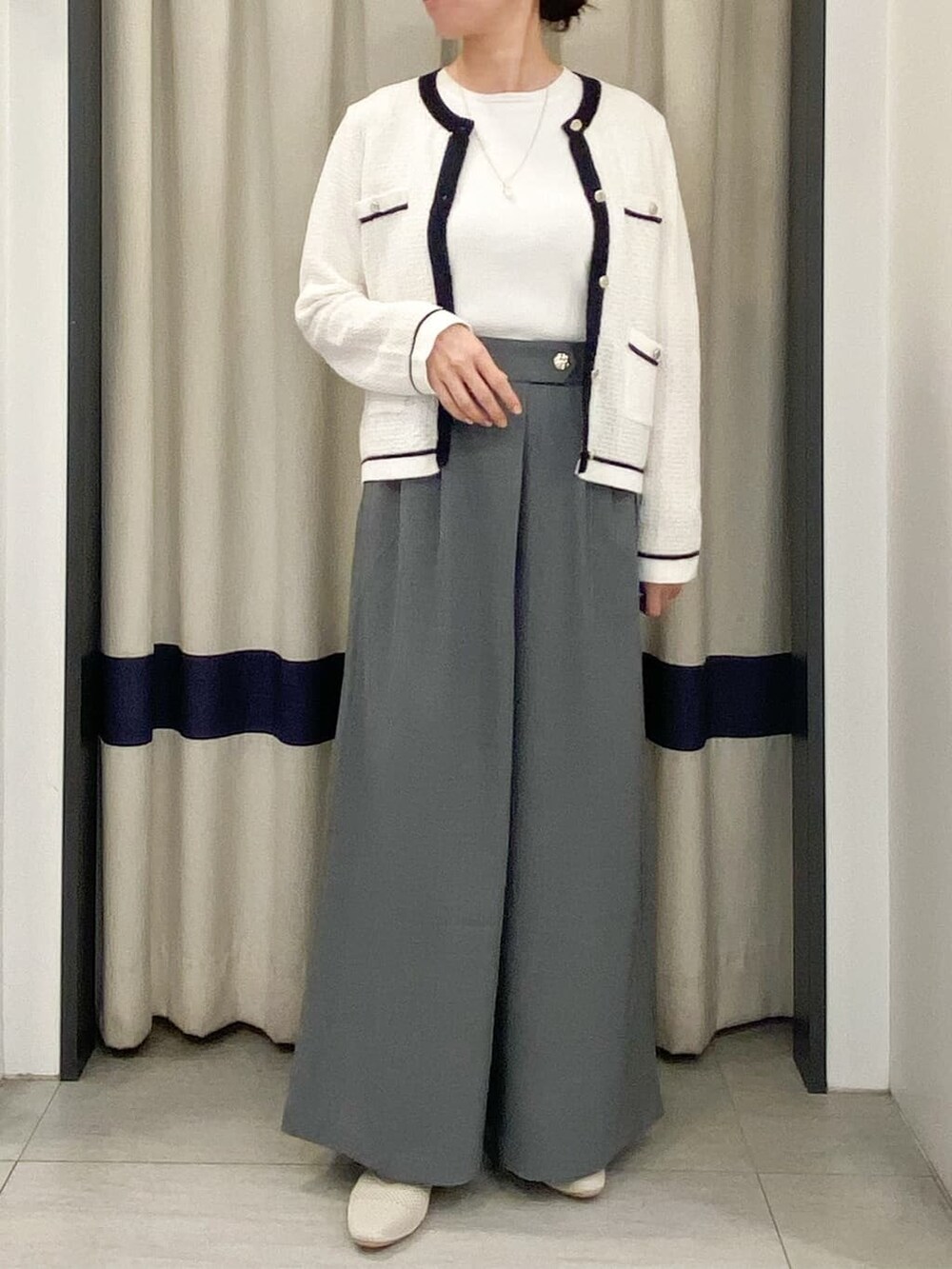 ホワイト系のカーディガン/ボレロ、ホワイト系のニット/セーター、グレー系のその他パンツを着用したレディースの春コーディネートの4枚目の写真