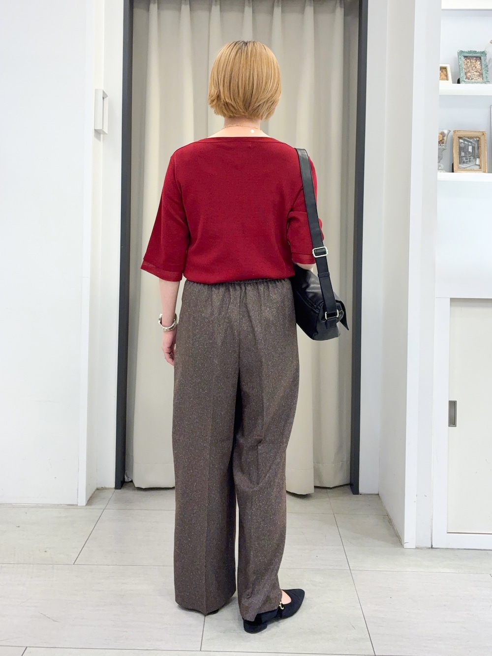 レッド系のニット/セーター、ブラウン系のその他パンツ、ブラック系のショルダーバッグを着用したレディースの秋コーディネートの3枚目の写真