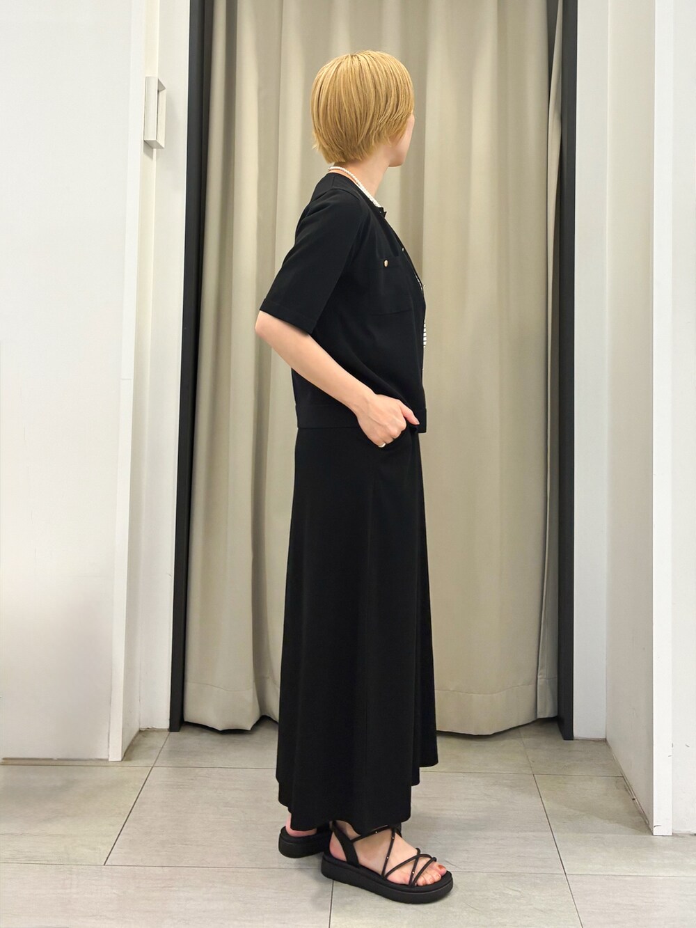 ホワイト系のTシャツ/カットソー、ブラック系のカーディガン/ボレロ、ブラック系のスカートを着用したレディースの夏コーディネートの2枚目の写真