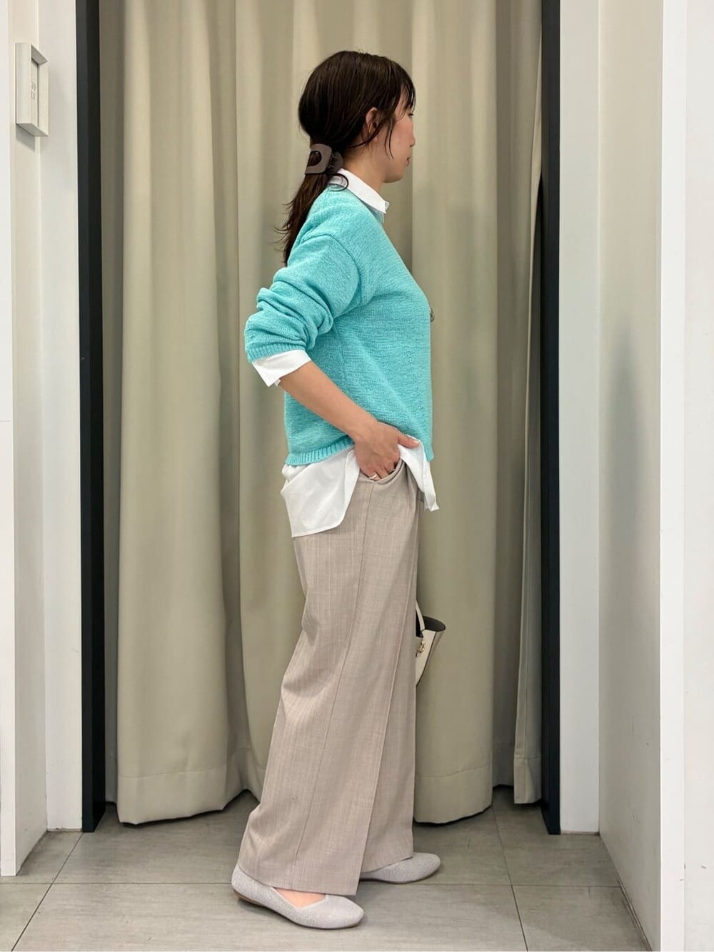 ブルー系のニット/セーター、ホワイト系のシャツ/ブラウス、ベージュ系のその他パンツを着用したレディースの春コーディネートの2枚目の写真