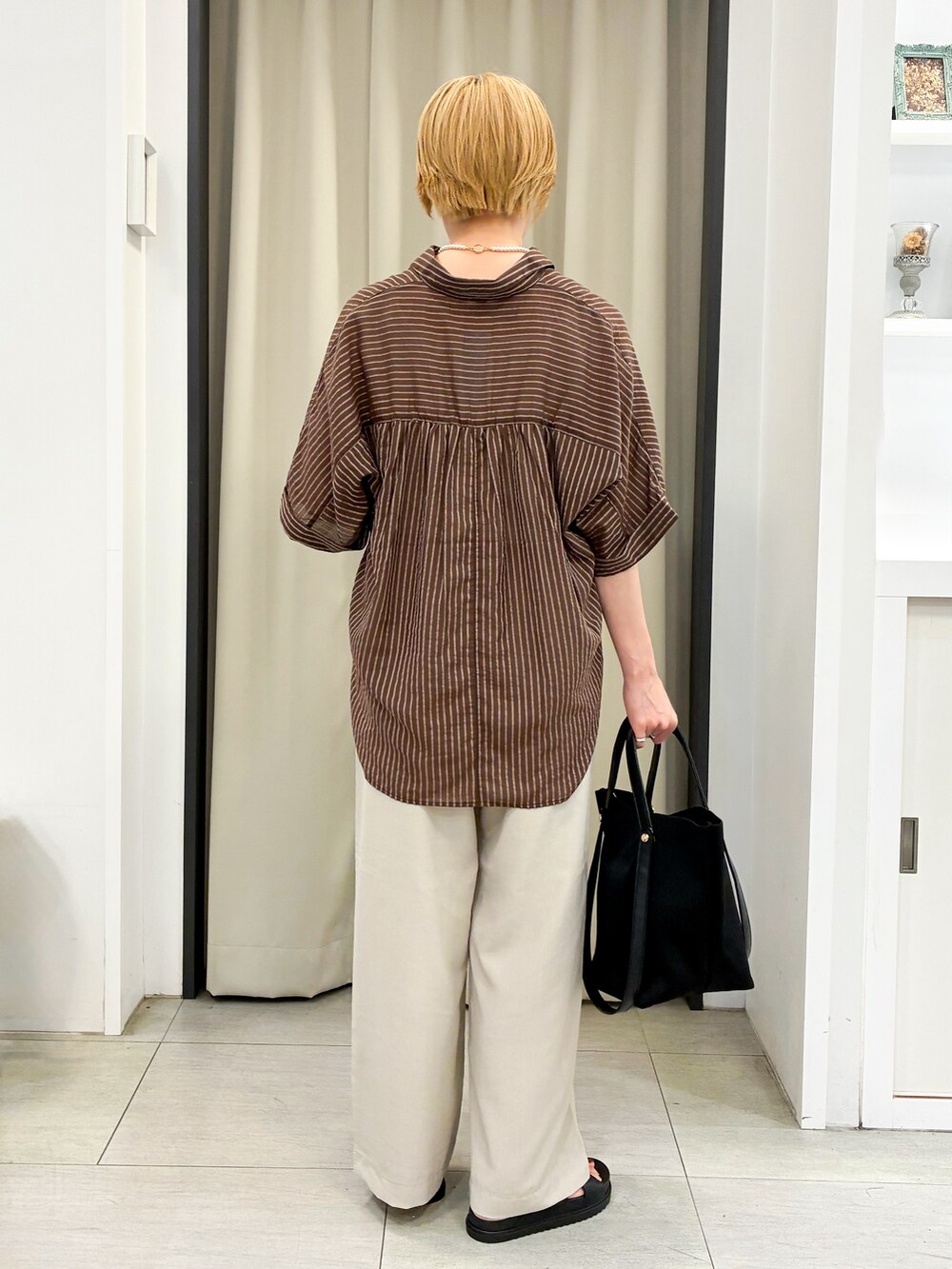 ブラウン系のシャツ/ブラウス、ベージュ系のその他パンツ、ブラック系のトートバッグを着用したレディースの夏コーディネートの3枚目の写真