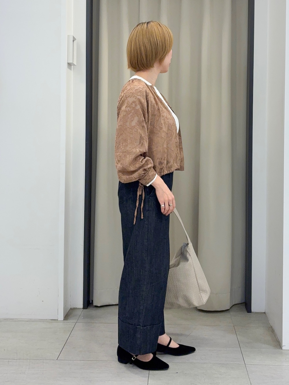 ベージュ系のシャツ/ブラウス、ホワイト系のTシャツ/カットソー、ブラック系のデニムパンツを着用したレディースの秋コーディネートの2枚目の写真