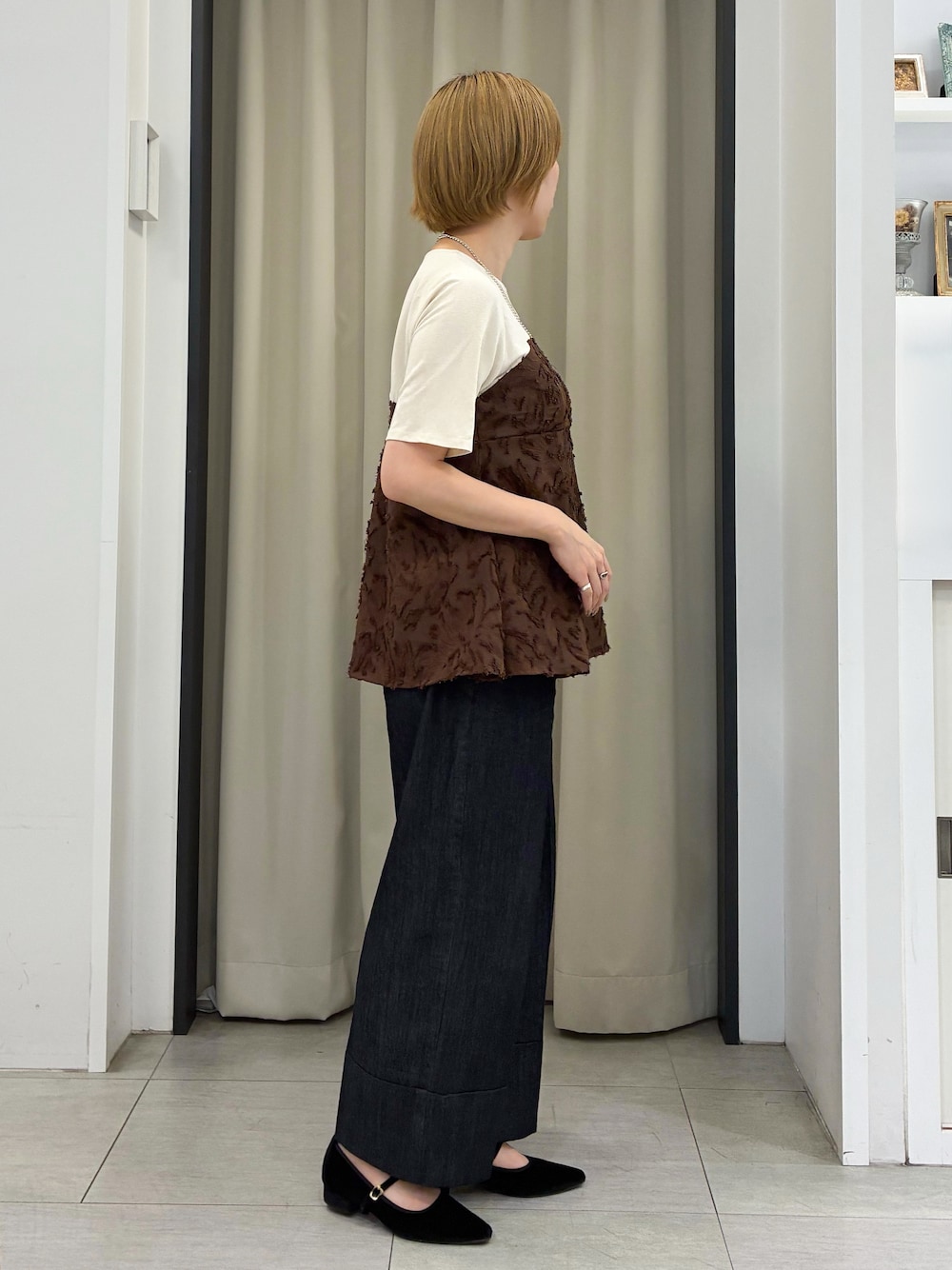 ブラウン系のTシャツ/カットソー、ブラック系のデニムパンツ、ブラック系のショルダーバッグを着用したレディースの秋コーディネートの2枚目の写真