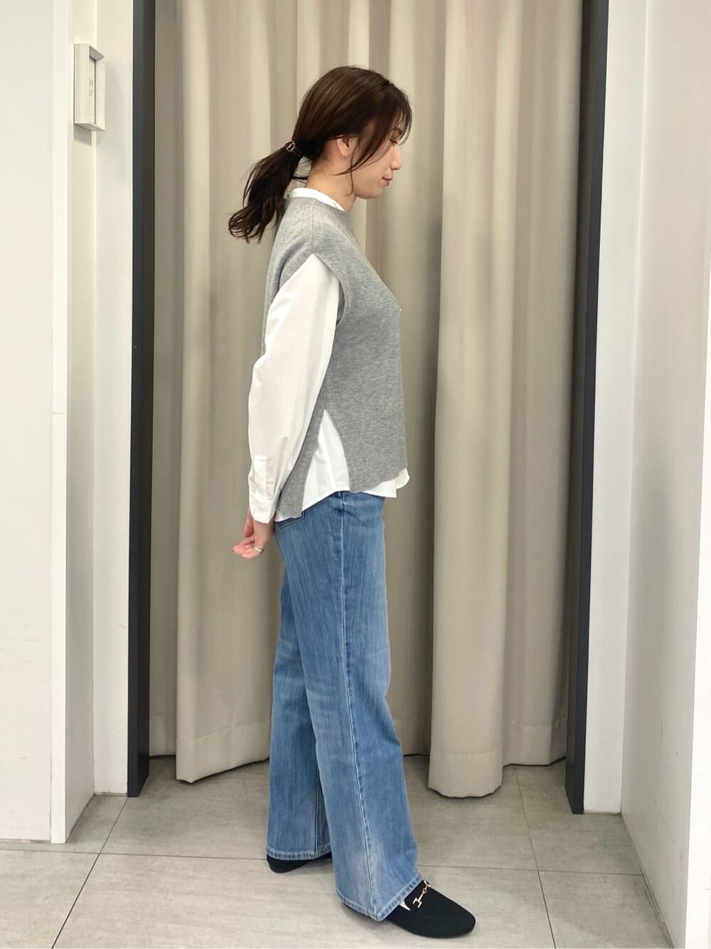 グレー系のシャツ/ブラウス、ブルー系のデニムパンツ、ブラック系のショルダーバッグを着用したレディースの冬コーディネートの2枚目の写真