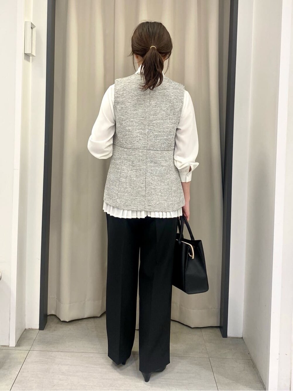 ホワイト系のシャツ/ブラウス、ブラック系のベスト、ブラック系のその他パンツを着用したレディースの冬コーディネートの3枚目の写真
