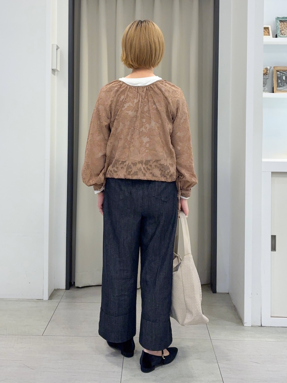 ベージュ系のシャツ/ブラウス、ホワイト系のTシャツ/カットソー、ブラック系のデニムパンツを着用したレディースの秋コーディネートの3枚目の写真