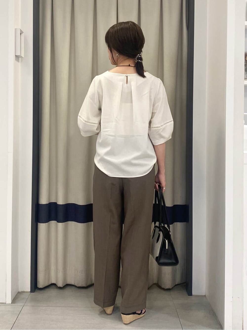 ホワイト系のシャツ/ブラウス、ブラウン系のその他パンツ、ブラック系のボストンバッグを着用したレディースの夏コーディネートの3枚目の写真