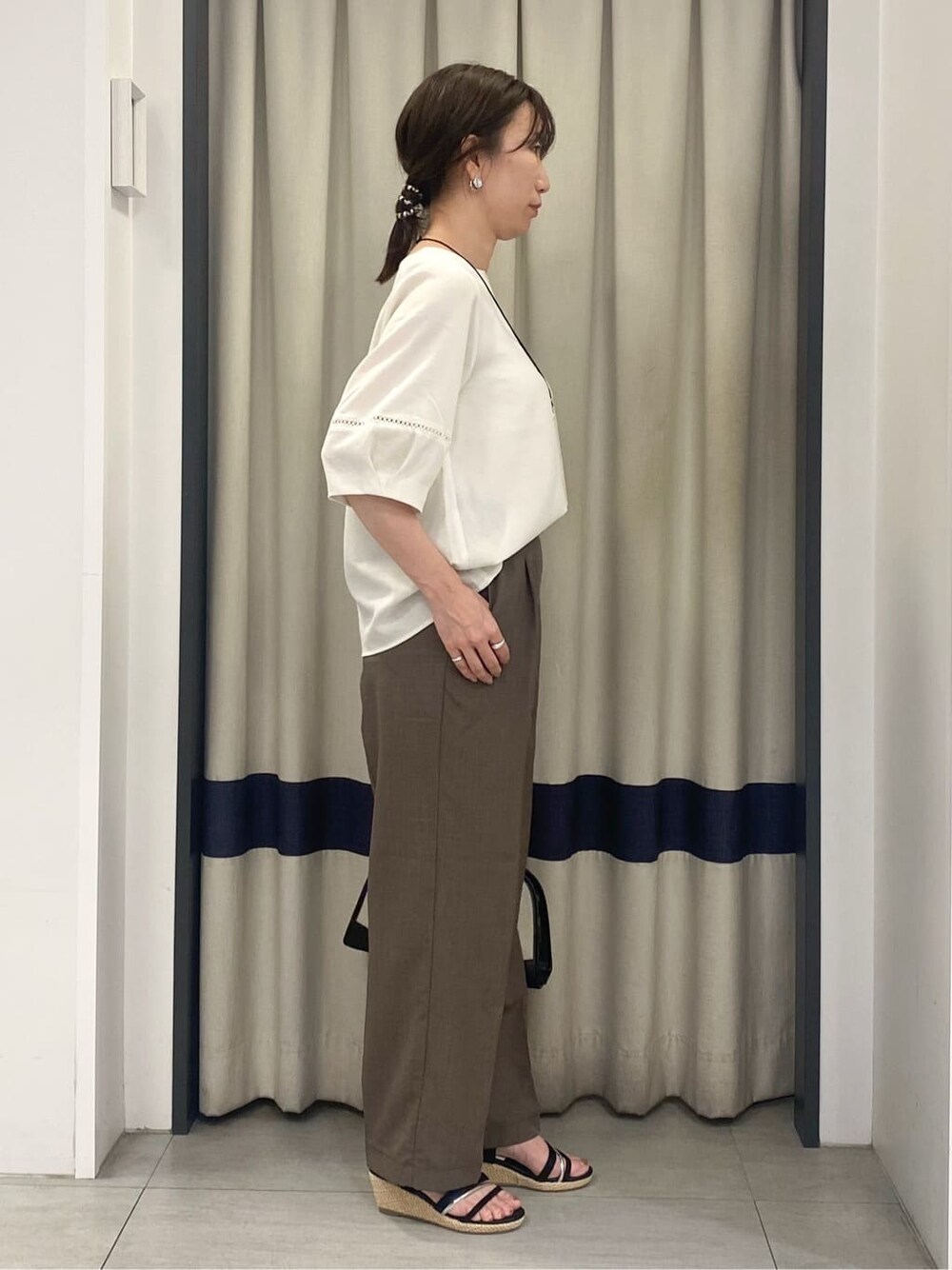 ホワイト系のシャツ/ブラウス、ブラウン系のその他パンツ、ブラック系のボストンバッグを着用したレディースの夏コーディネートの2枚目の写真