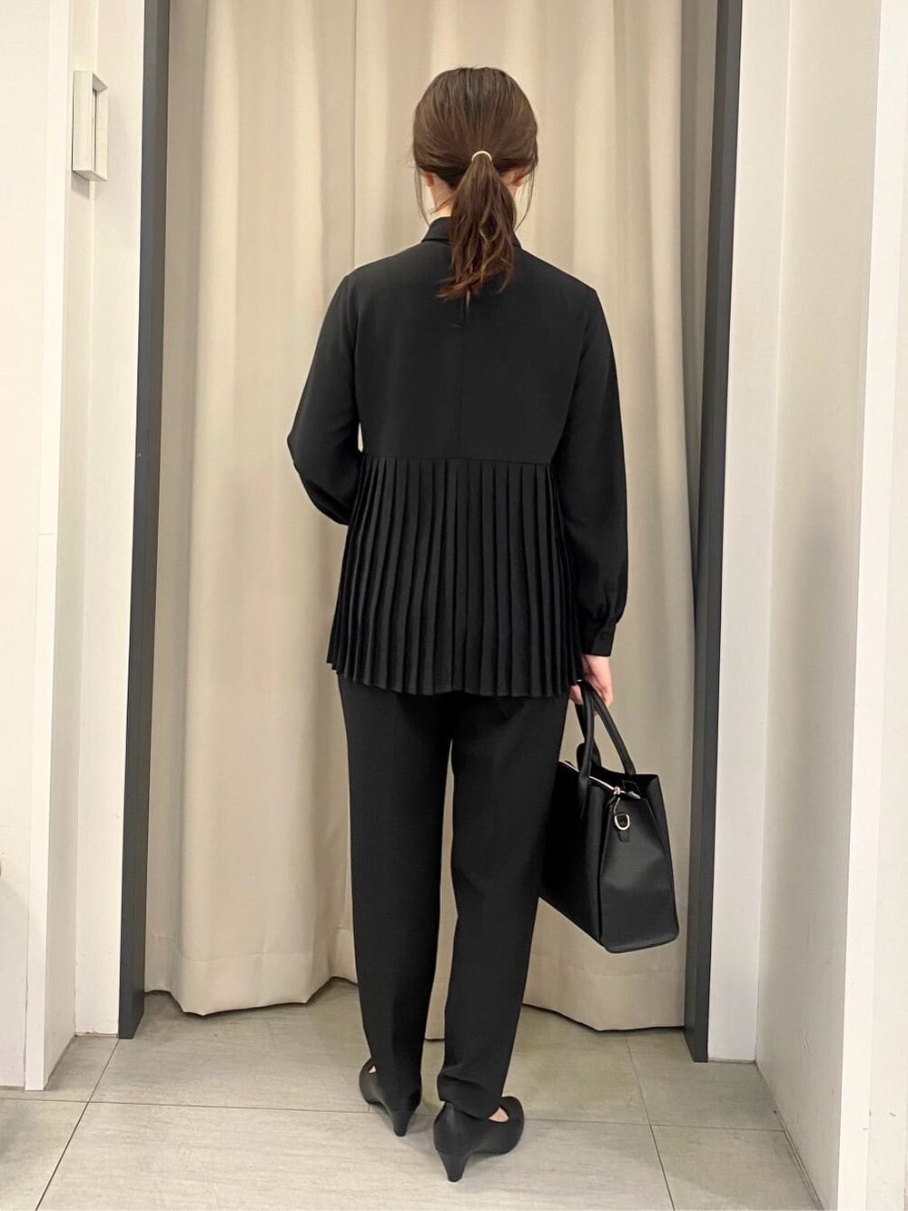 ブラック系のシャツ/ブラウス、ブラック系のその他パンツ、ブラック系のトートバッグを着用したレディースの冬コーディネートの3枚目の写真