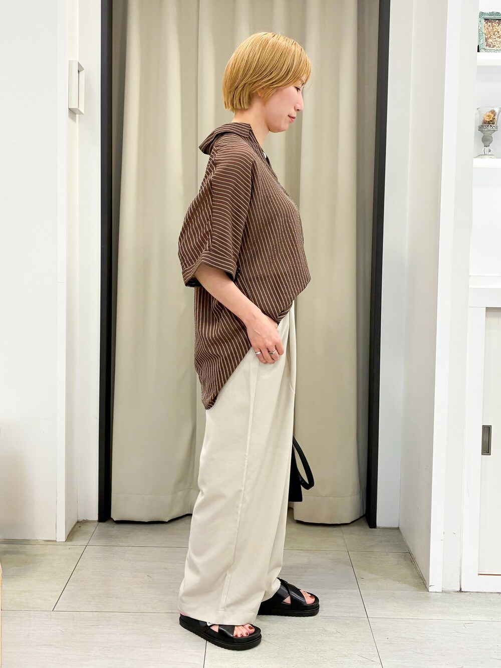 ブラウン系のシャツ/ブラウス、ベージュ系のその他パンツ、ブラック系のトートバッグを着用したレディースの夏コーディネートの2枚目の写真