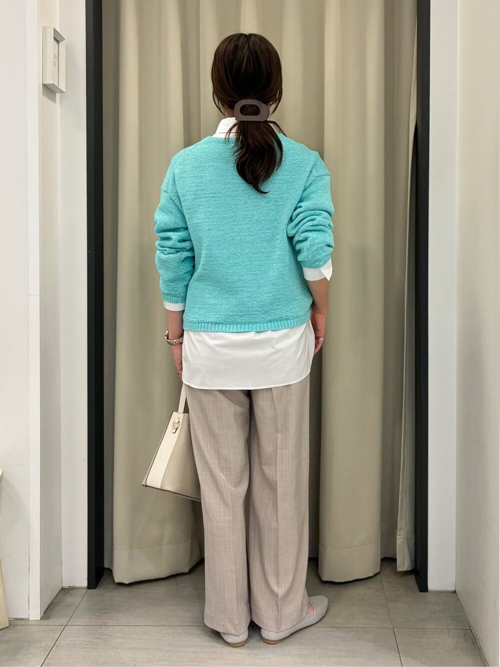 ブルー系のニット/セーター、ホワイト系のシャツ/ブラウス、ベージュ系のその他パンツを着用したレディースの春コーディネートの3枚目の写真