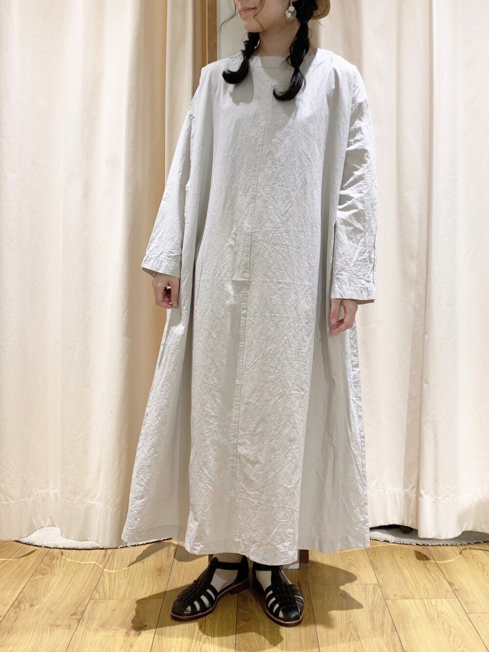 グレー系のワンピース、ブラック系のサンダル、ホワイト系のスカートを着用したレディースの春コーディネートの2枚目の写真