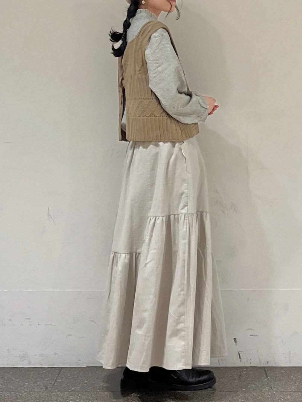 ベージュ系のベスト、ブラック系のシャツ/ブラウス、ベージュ系のスカートを着用したレディースの冬コーディネートの3枚目の写真