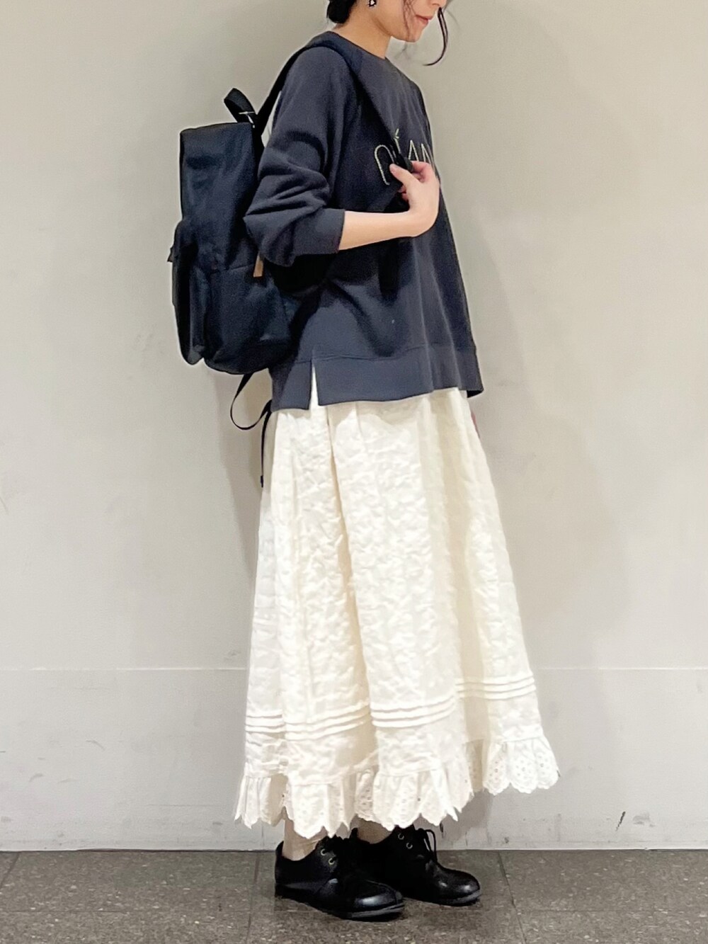 グレー系のTシャツ/カットソー、ホワイト系のスカート、ブラック系のハンドバッグを着用したレディースの冬コーディネートの5枚目の写真