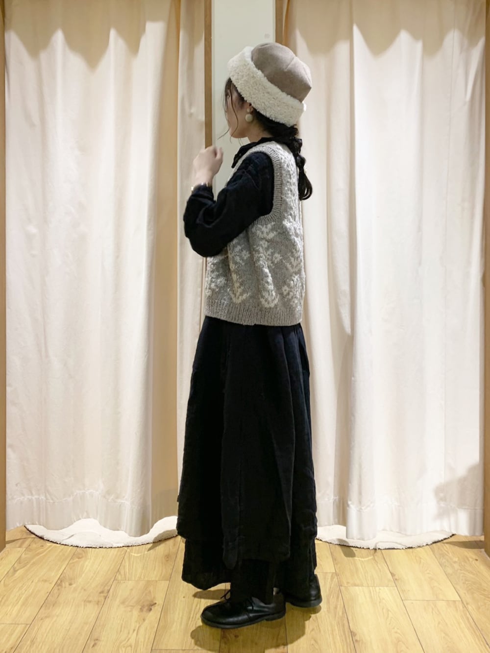 ブラック系のワンピース、ブラウン系のベスト、ブラック系のスカートを着用したレディースの秋コーディネートの2枚目の写真