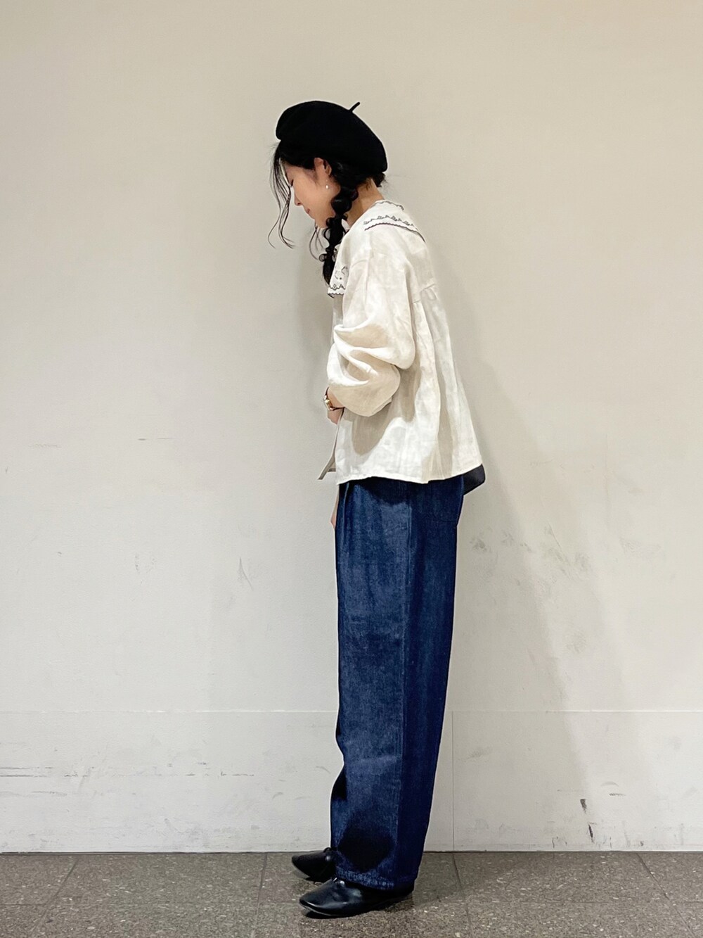 ベージュ系のシャツ/ブラウス、ブルー系のデニムパンツ、ブラック系のハンドバッグを着用したレディースの冬コーディネートの2枚目の写真