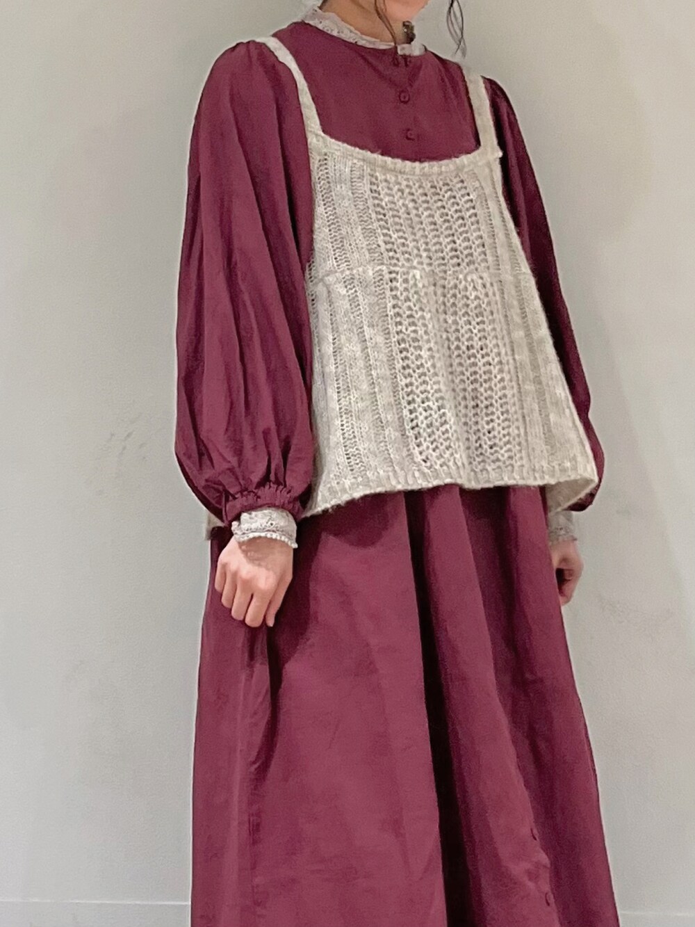 レッド系のワンピース、ホワイト系のニット/セーター、ベージュ系のスカートを着用したレディースの秋コーディネートの5枚目の写真