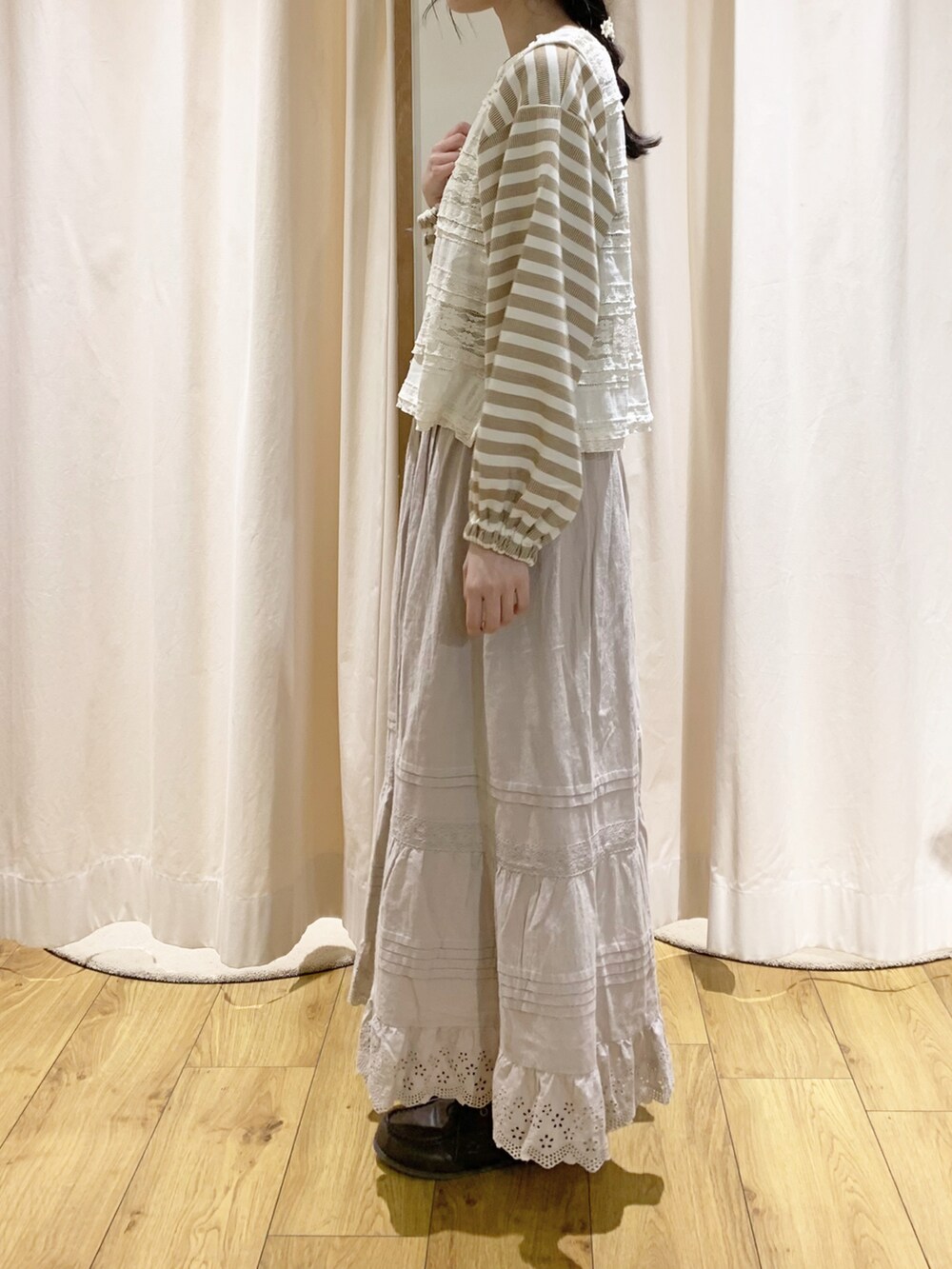 ホワイト系のベスト、イエロー系のTシャツ/カットソー、ホワイト系のスカートを着用したレディースの秋コーディネートの3枚目の写真