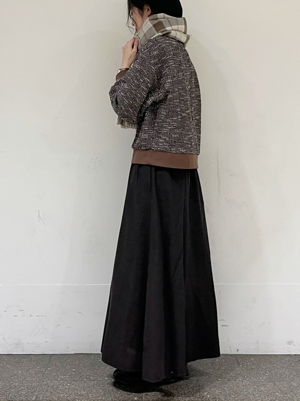 ブラウン系のTシャツ/カットソー、グレー系のスカート、ベージュ系のストール/ショールを着用したレディースの秋コーディネートの4枚目の写真