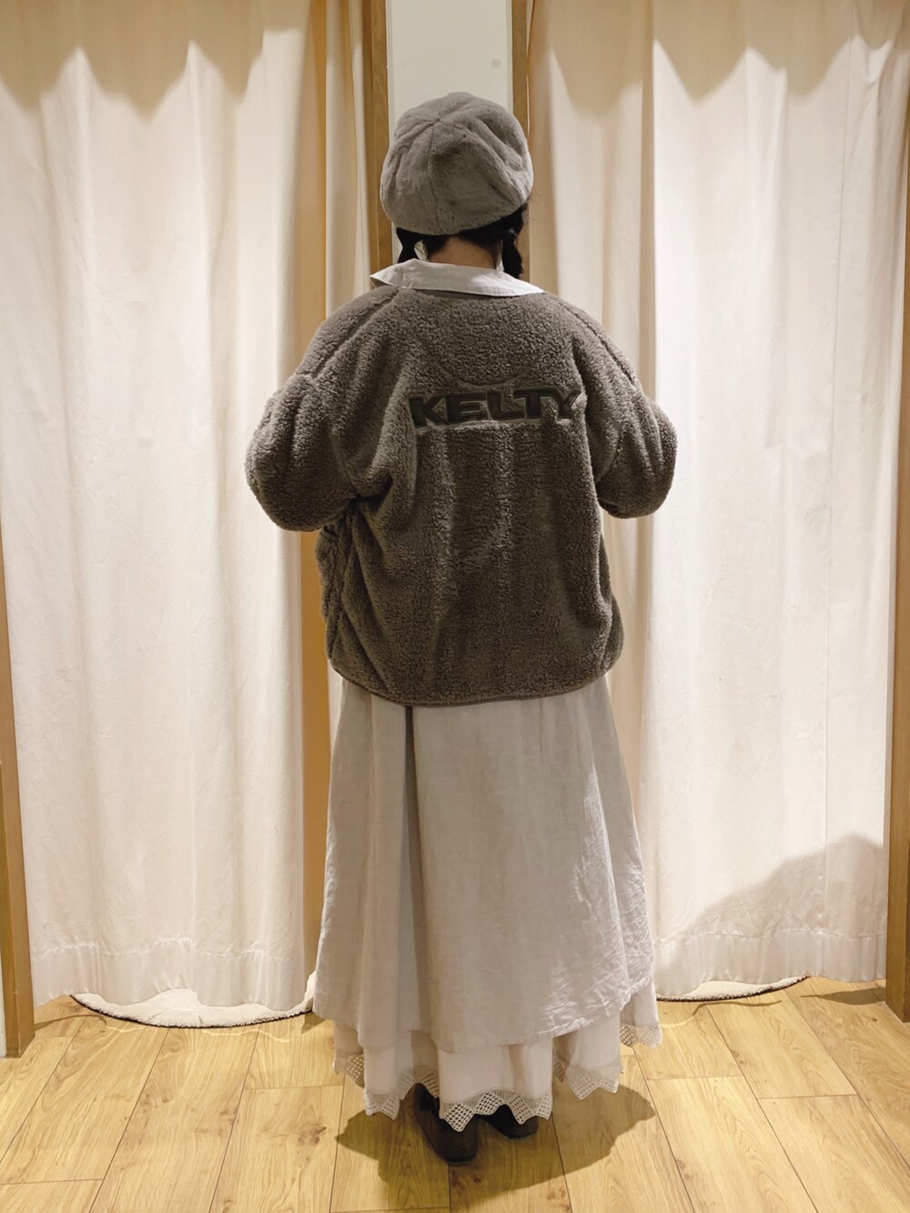 ブラウン系のカーディガン/ボレロ、ベージュ系のワンピース、ベージュ系のスカートを着用したレディースの秋コーディネートの4枚目の写真