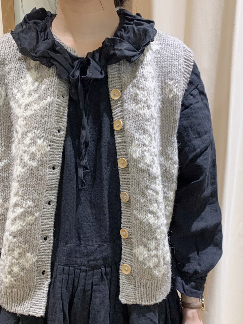 ブラック系のワンピース、ブラウン系のベスト、ブラック系のスカートを着用したレディースの秋コーディネートの4枚目の写真