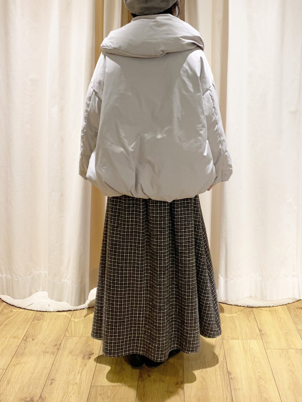 ベージュ系のブルゾン、グレー系のニット/セーター、ブラウン系のカーディガン/ボレロを着用したレディースの冬コーディネートの2枚目の写真